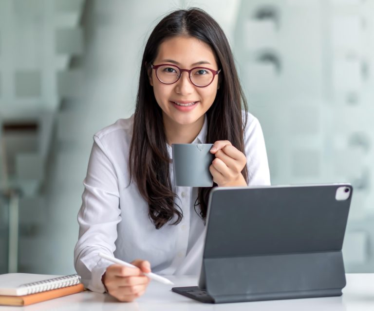 incorporation Hong Kong, woman on tablet smiling drinking coffee