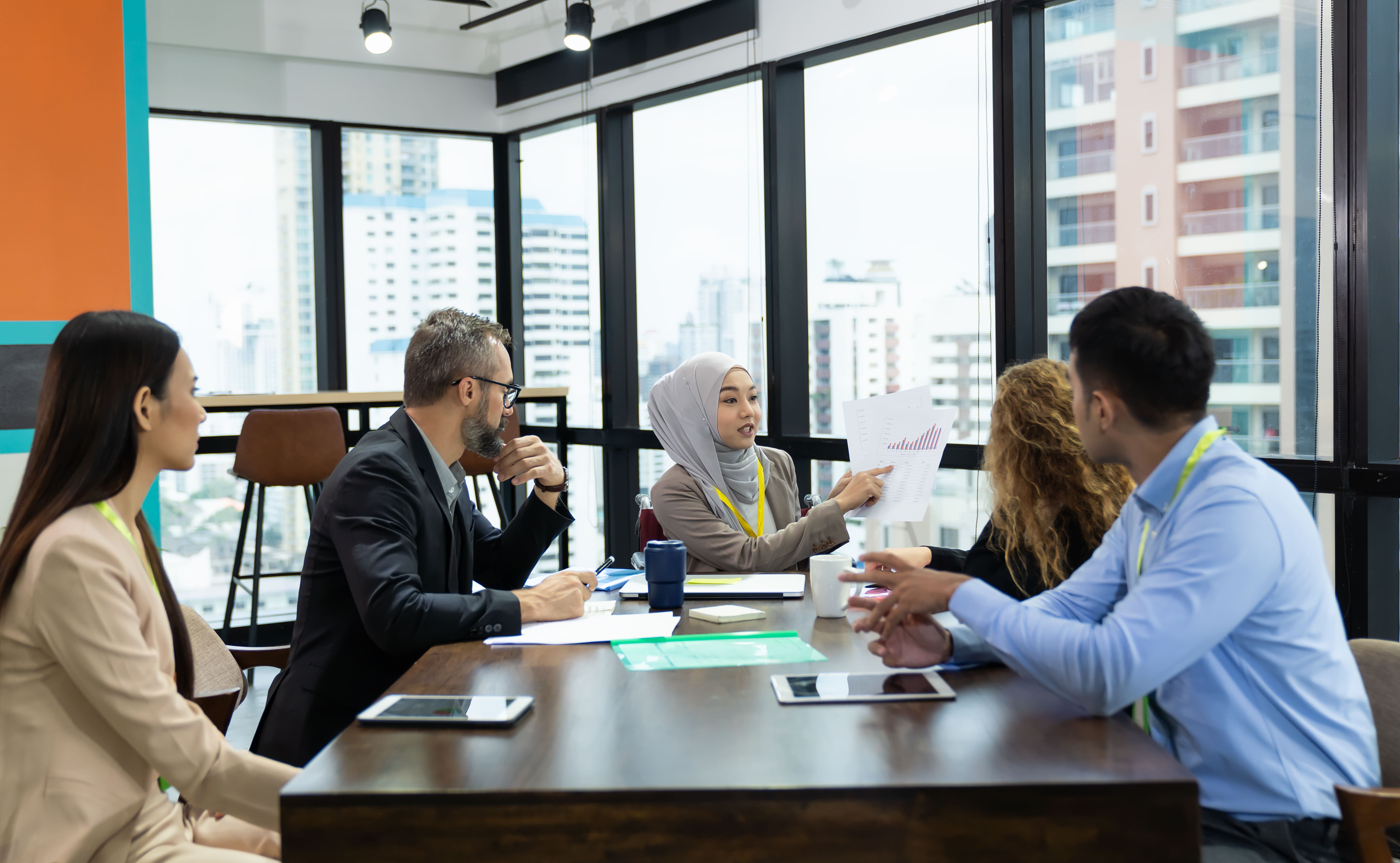 5 people smlining in a board room in Singapore